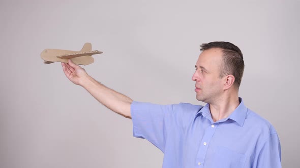 Fly fear. Man Holding Airplane in Hand alt