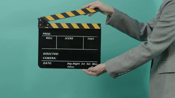 Movie slate or clapperboard hitting. Business woman holding empty film slate and clapping it. alt