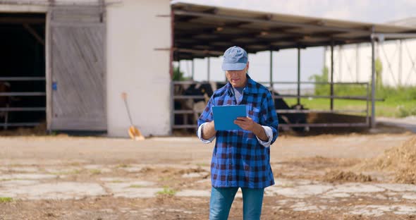 Farmer Gesturing While Writing on Clipboard Against Barn alt