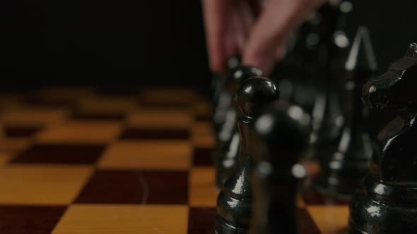 Human's Hand Makes First Opponent Move By Black Pawn E7 E5 in Chess Game alt