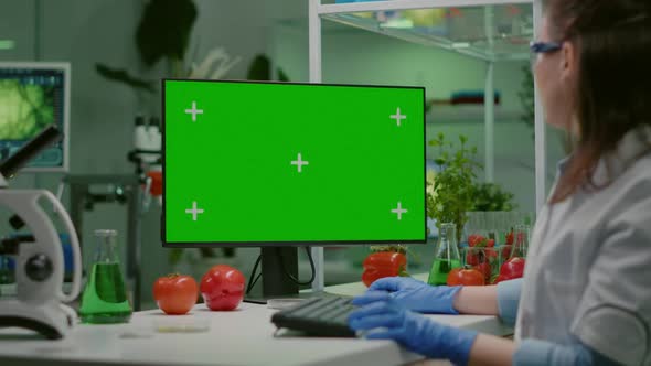 Scientist Woman Working on Computer with Mock Up Green Screen alt