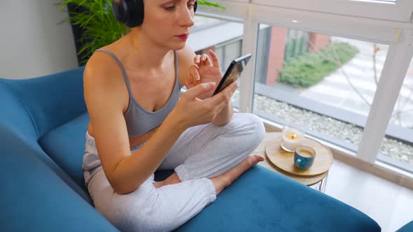 Woman in Wireless Headphones Listening to Music and Using Mobile Apps or Communicates on Social alt