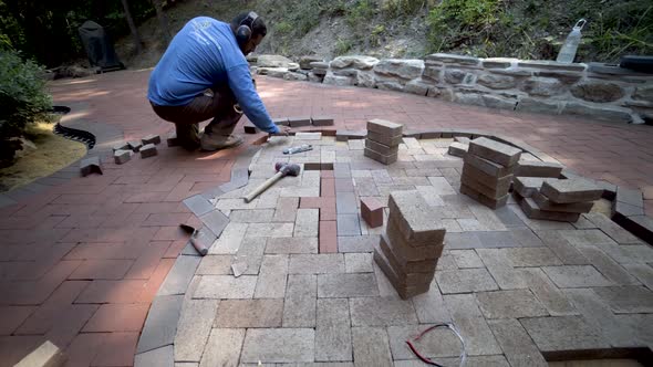Wide angle lens shows the custom made stone wall and brick paving artisan in the distance as camera alt
