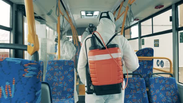 Sanitation Men Are Doing Chemical Treatment of a Bus Interior. Disinfection, Antivirus Protective alt
