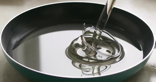 Closeup of Pouring Oil Into a Frying Pan for Cooking