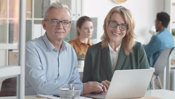 Female HR Manager Posing with New Senior Employee in Office and Smiling alt