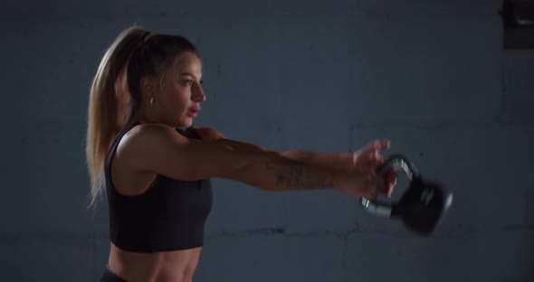 Muscular Woman Doing Exercises with Kettlebell alt