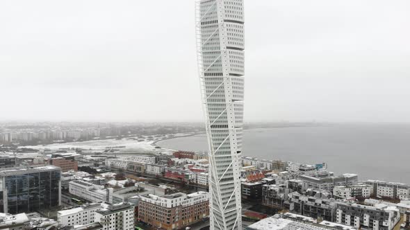 Drone flying upwards, turning torso, Malmö Sweden, wintertime while it is snowing a little alt