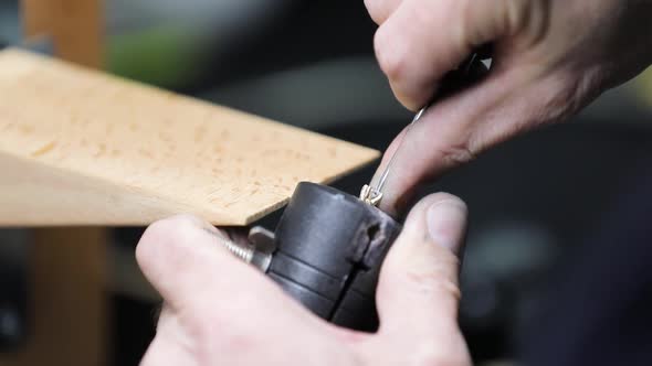 jeweller sitting at desk and making jewelry in workshop alt