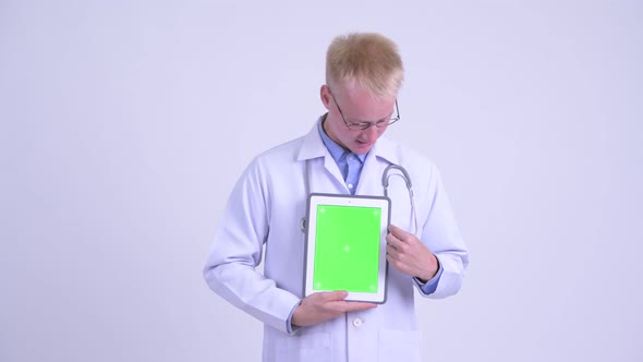 Happy Young Blonde Man Doctor Explaining While Showing Digital Tablet alt