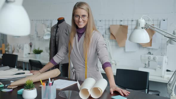Beautiful Young Woman Clothes Designer Standing Indoors in Workplace Smiling Looking at Camera alt