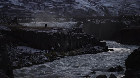 Godafoss Waterfall with Tourists Silhouette Walking at Dusk