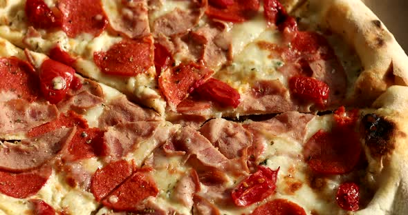 Delivery pizza box. Chopped hot pizza in a cardboard box. Pizza with meat and cheese. alt