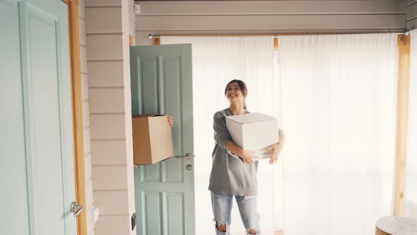 Husband and Wife Are Coming Inside New House and Bringing Boxes with Things After Relocation alt