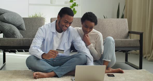 Young Black Man Holding Credit Banking Card Payment Information with Focused Smiled Millennial Afro alt