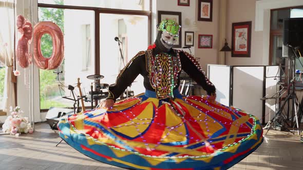 Man in mask show traditional arabic egypt performance entertainment at event. Tanura dance indoors alt