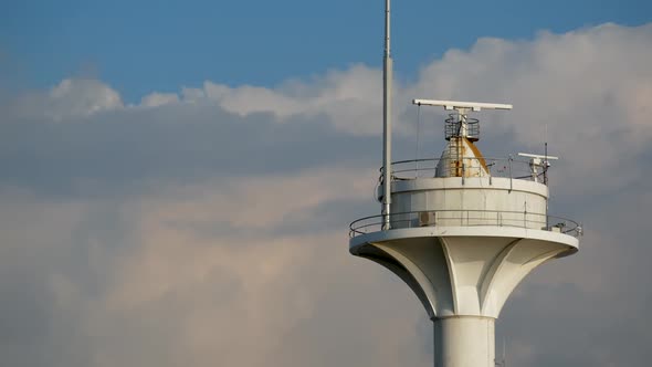 Radio Beacon in Navigation on Blue Sky with Clouds Background