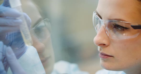 Scientist Analyzing Tubes at Laboratory alt