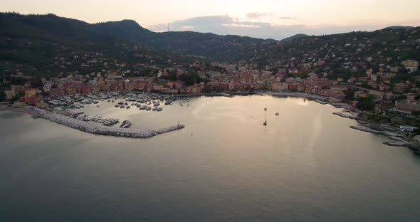 Romantic golden hour aerial view over charming Italian coastal town, Liguaria alt