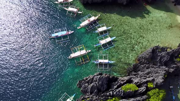 Aerial Fly-Over View of Secret Lagoon with Karst Cliffs and White Beach. El-Nido, Philippines
