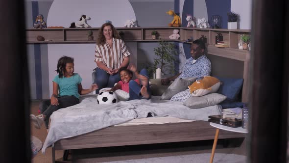 Happy American Family Playing Ball in Bedroom alt