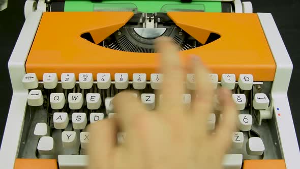 Hand typing on a typewriter stylish orange vintage mechanical White keyboard green paper