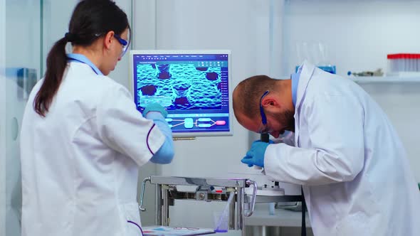 Team of Experienced Biologists Working on Microscopes in Laboratory alt