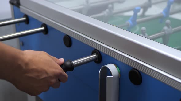 Man plays foosball on vacation with friends. Table football. alt