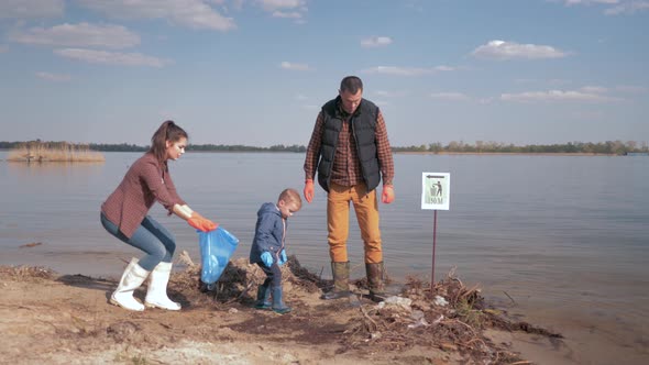Environmental Solutions, Child Boy Helps Mother and Father Volunteer Activists Clean Up Dirty River alt