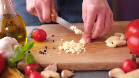 Making Pasta Carbonara  Cut Garlic with Knife on a Wooden Cutting Board alt