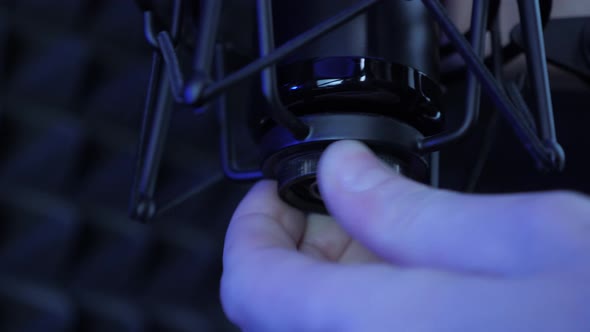 Audio engineer is connecting professional sound microphone into stand, close up alt