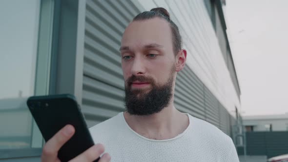 Male Millennial Hipster Holding Modern Smartphone Texting Message alt