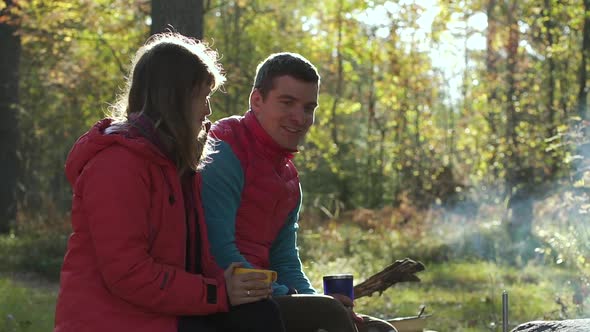 Traveling Young Couple Talking and Relaxing in Camping on Autumn Day alt