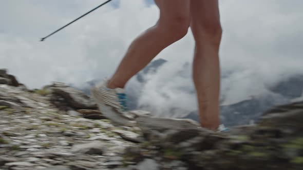 Woman Trail Running in a Big Mountains with Pole Sticks