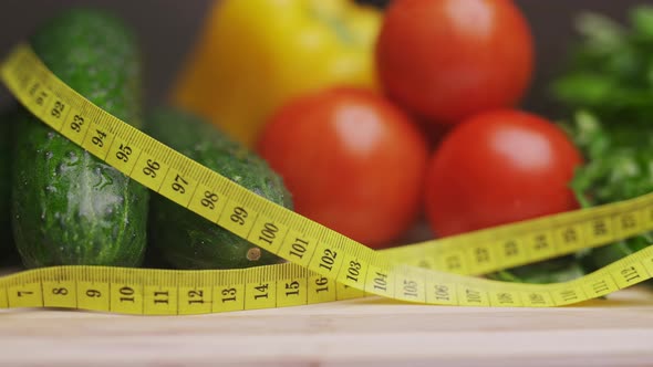 A Side View of Yellow Measuring Tape and Fresh Vegetables on a Wooden Cutting Board alt