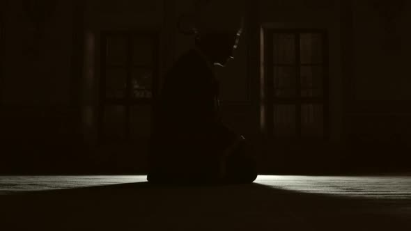 Silhouette of people praying in mosque. alt