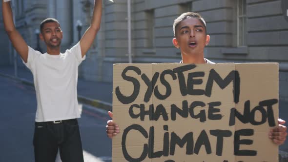 Two mixed race men on a protest march holding placards raising hands and shouting alt