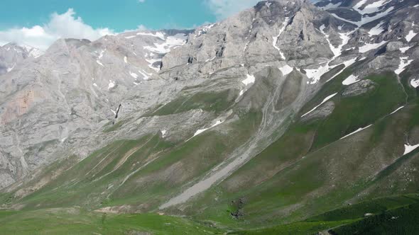 Snowy peaks among mountains in spring