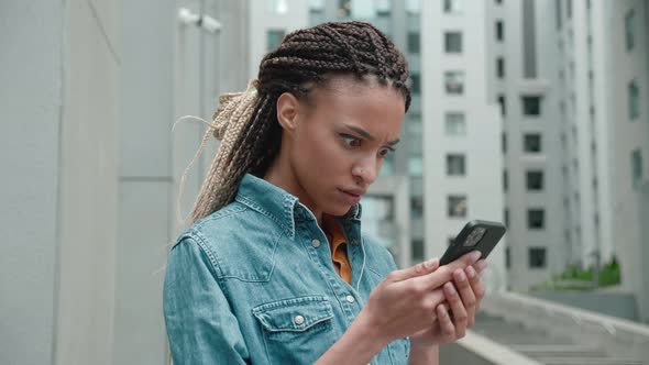 Shocked Frustrated African Mixed Race Woman Student Feel Stressed Look at Smartphone Screen Worried alt