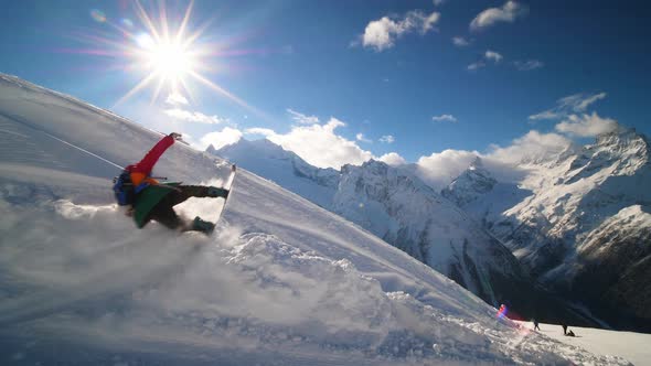 A Snowboarder in an Rainbow Ski Suit Rolls at High Speed and Falls on the Track alt