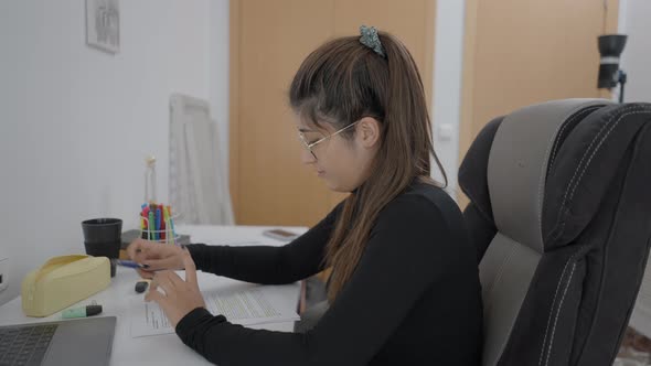 A Young Student of Colombian Universitary Sitting at a Table and Studying Sincerely alt