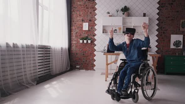 Adult Man in Wheelchair Using Virtual Reality Glasses and Interf