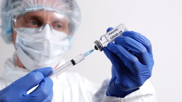 Doctor Fills Injection syringe with Vaccine COVID-19