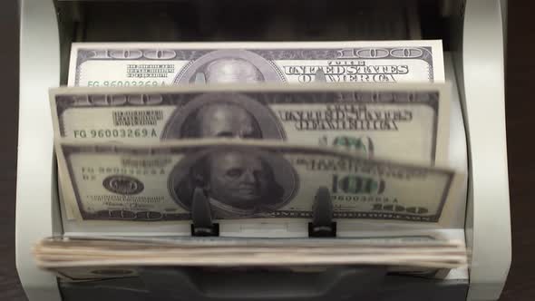 Hundred-dollar bills counted by a special machine for money. Large amount of money is converted alt