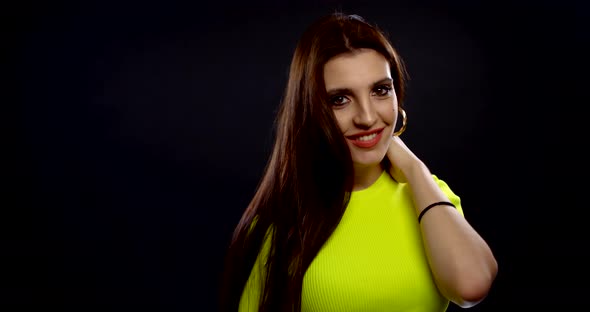 Charming Brunette Woman Is Smiling and Playing with Her Long Hair, Indoors Portrait alt