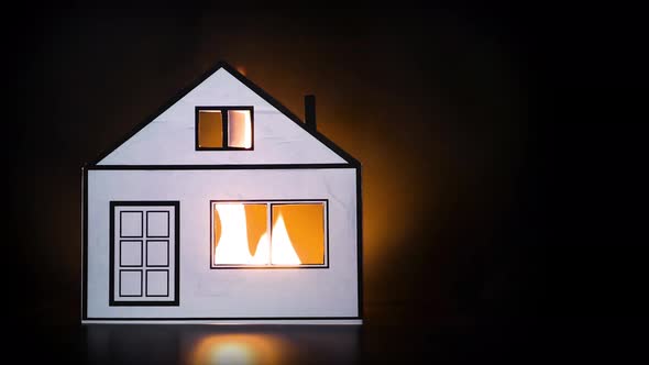 Insurance concept. Burning paper house as a symbol of fire damage.