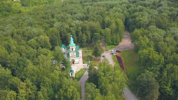 A beautiful green forest with a monastery in the middle alt