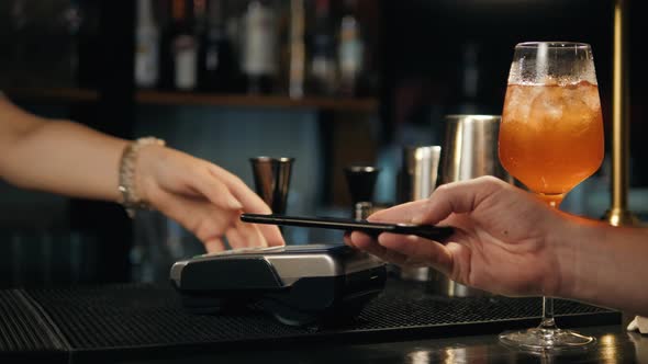 Closeup of Woman Making Payment Through NFC in Bakery Cafe Restaurant Bar for Cocktail Lemonade alt