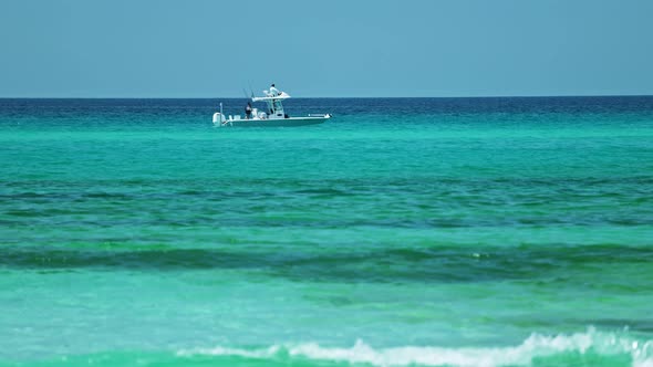 Boat floating in crystal clear ocean water alt