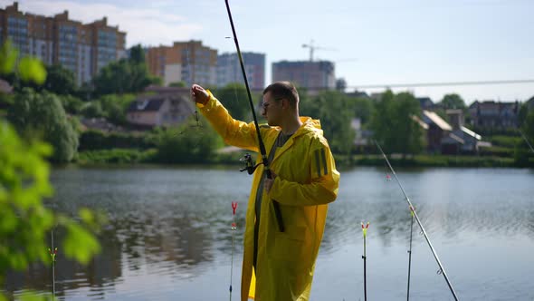 Side View Portrait of Concentrated Fisher Examining Hooks on Fishing Rod in Slow Motion Standing on alt